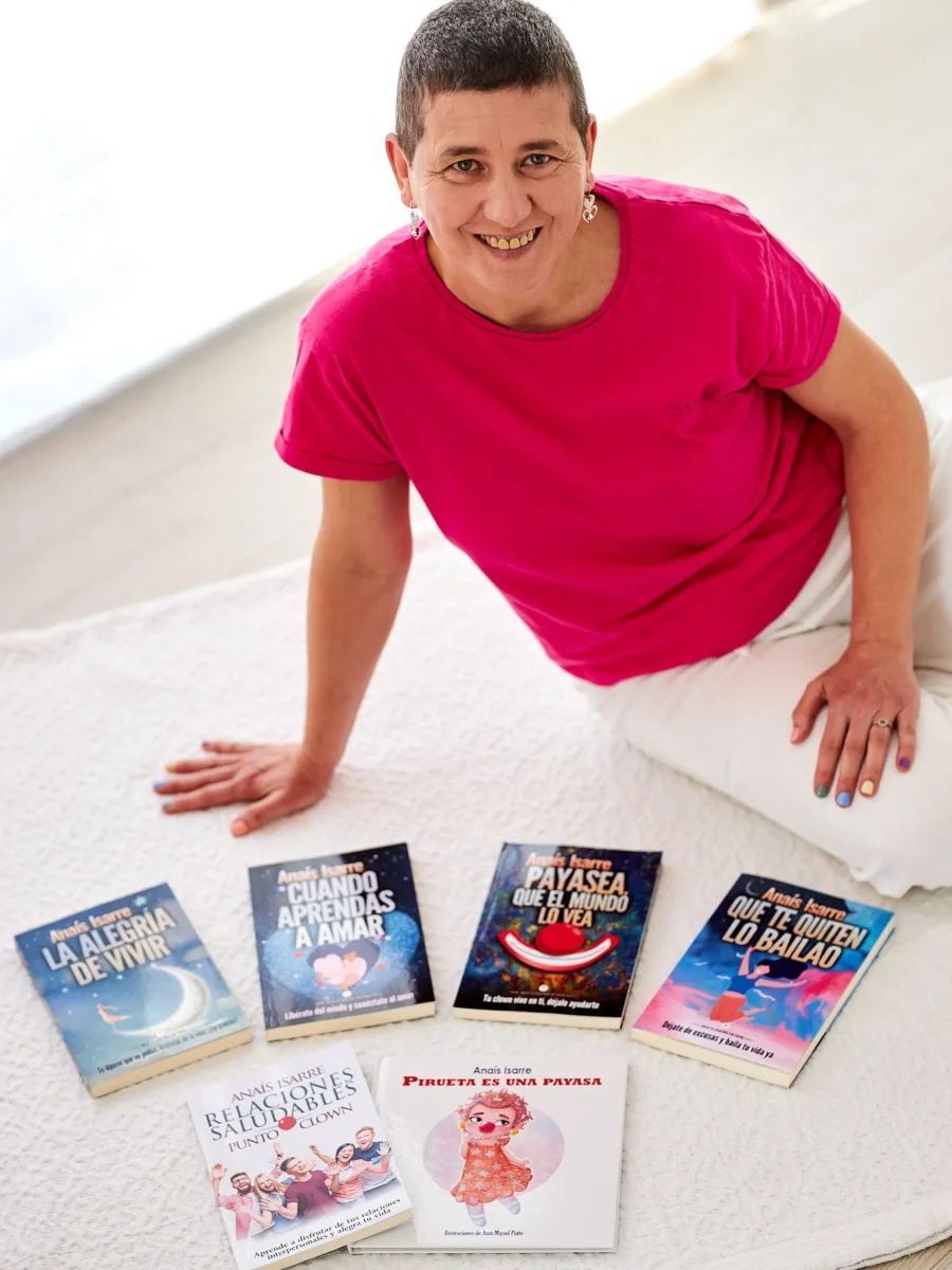 Anaís Isarre - Autora de la saga La Alegría de Vivir Anaís Isarre sentada en el suelo junto a sus 6 libros de desarrollo personal. Autora de la saga la Alegría de Vivir.